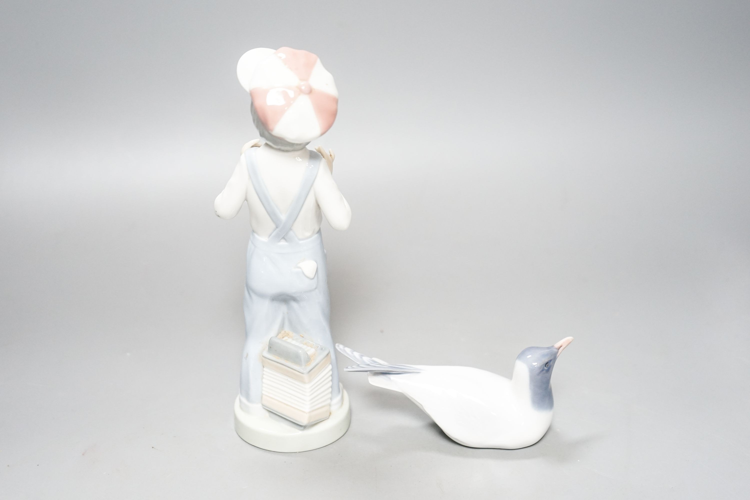 A Lladro figure of a young boy, 21.5cm high, a Royal Copenhagen model a tern, a cased miniature Royal Worcester jug, signed Norway?